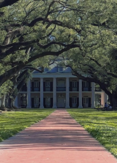 The quarter-mile avenue of live oaks at Oak Alley Plantation arching over a brick path, with the columned Big House at the far end