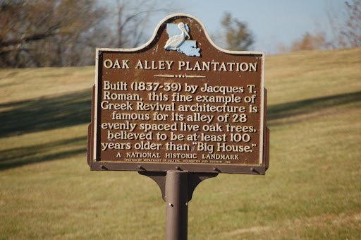 A Louisiana historical marker for Oak Alley Plantation standing beside the Great River Road